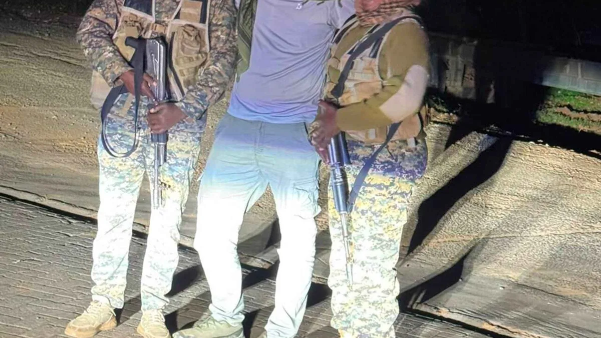 Armed rangers in camouflage standing beside a vehicle at night