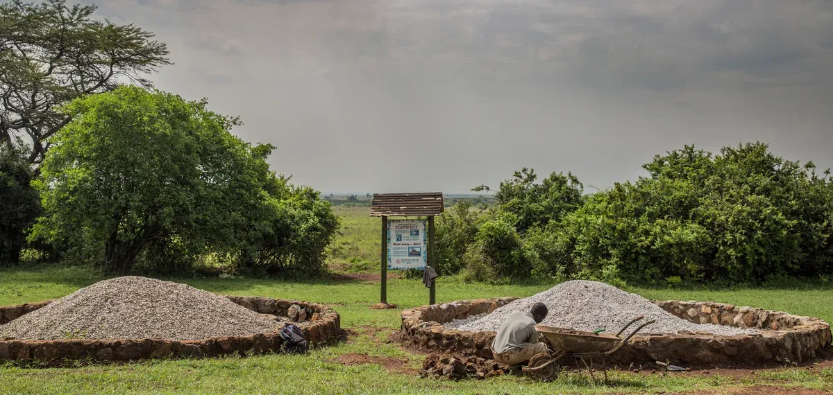 Grey cairns of ivory ash at the Ivory Burning Site in Nairobi National Park, a signboard behind them